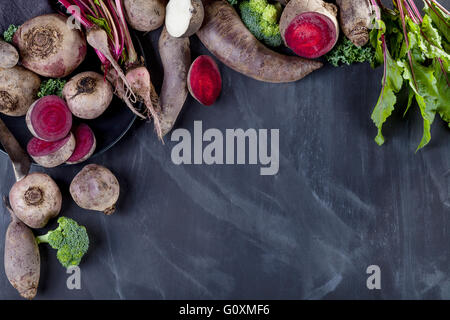 Die rote Bete, Grünkohl, Brokkoli und schwarze Rübe auf dem Teller mit Messer liegen auf Tafel Stockfoto