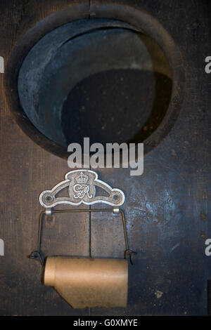Alten Toilettenpapierhalter mit GR (George Rex) Logo und authentischen antiken Papier, von Thomas Crapper Collection, Stratford-upon-Avon, Warwickshire, England Stockfoto