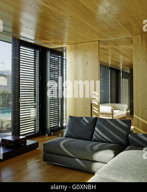 PX-Haus, La Garriga, Spanien. Sonniges Wohnzimmer mit modernen graue Couch und vom Boden bis zur Decke reichenden Fenster. Stockfoto