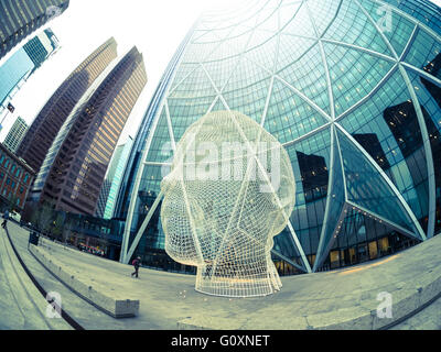 Ein Fischauge Blick auf die Skulptur Wonderland von Jaume Plensa vor The Bow Wolkenkratzer in Calgary, Alberta, Kanada. Stockfoto