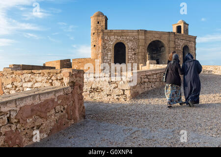 Menschen zu Fuß entlang der alten Stadtmauern von Essaouira, Marokko Stockfoto