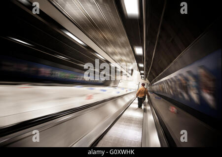 FAHRENDE ROLLTREPPE mit Einzelfigur, die nach unten fährt. London U-Bahn, UK Stockfoto
