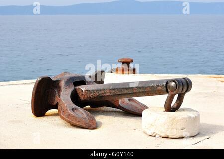 Alte rostige Schiff Anker auf Port mit Meer im Hintergrund. Podgora, Kroatien Stockfoto