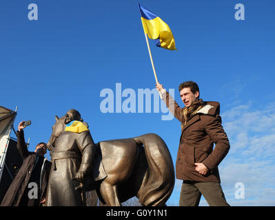 Kryvyi Rih, Ukraine - Dezember 13, 2015: Mann winkt die ukrainische Flagge in der Nähe von Monument Kryvyi Rih Stadt Gründer Kosak Rih Stockfoto