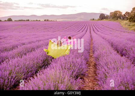Zwei Mädchen laufen durch Lavendelfeld, Kazanlak, Bulgarien Stockfoto