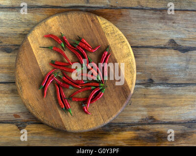 Rote scharfe Chilischoten auf Schneidbrett aus Holz Stockfoto