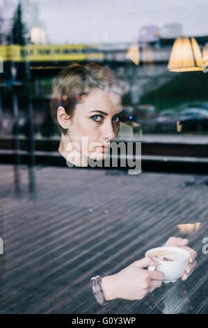 Frau, die im Café Kaffee trinkt Stockfoto