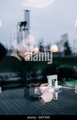 Frau, die im Café Kaffee trinkt Stockfoto