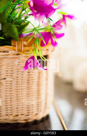 Korb mit dekorativen Blumen auf dem Tisch als Teil des Interieurs. Stockfoto