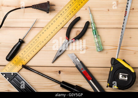 Aufbau von verschiedene manuelle und elektrische Werkzeuge auf einem Holztisch Stockfoto