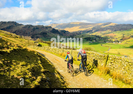 Mountainbiker absteigen Kentmere talwärts im Lake District Stockfoto