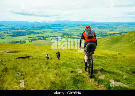 Mountainbiker Abstieg vom Grat in den Pennines mit der Seenplatte Fjälls Kreuz fiel am Horizont Stockfoto