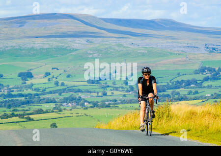 Radfahrer am Anstieg der Lythe fiel Lancashire Yorkshire Höhepunkt der Whernside in der Ferne Stockfoto