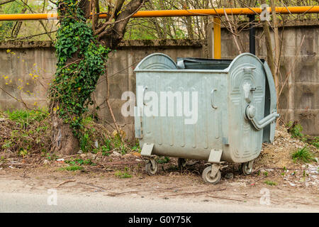 Offenen Müllcontainer und Baum Closeup auf dem Hintergrund der Betonwand Stockfoto