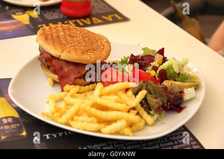 Cheeseburger mit Fleisch, Speck und Salat Stockfoto