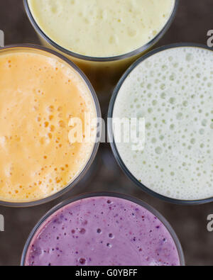 Eine Gruppe von vier Frucht-Smoothies. Beere, Lavendel, Papaya und Bananen Minze. Stockfoto