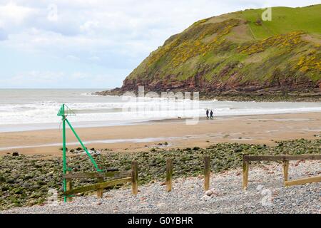 St. Bees Head. Paar, Hund am Strand hinter der Buhne.  Saint-Bienen, Cumbria, England, Vereinigtes Königreich, Europa. Stockfoto