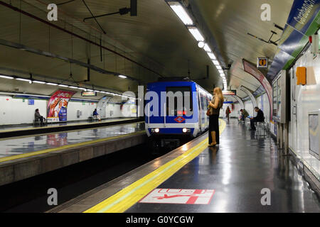 Blonde Frau stehen und lesen Tablet auf Plattform wie Ansätze, Carabanchel u-Bahnstation, Madrid, Spanien Stockfoto