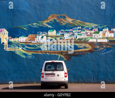 3. August 2015 - ein Wandbild an der Wand im Hafen, hinter einem geparkten Auto, zeigt berüchtigten Vulkan Eldfell (der 1973 ausbrach) drohend über Heimaey. Die größte und einzige bewohnte Insel in der Westmännerinseln Archipel Gruppe (Vestmannaeyjar), vor der Küste von Island, Heimaey verstreut ist abhängig von seiner Fischereiindustrie, aber bekannt für Vogelbeobachtung und vulkanischer Aktivität, Tourismus ist ein wachsender Sektor der Wirtschaft Heimaey mit Island immer ein beliebtes Touristenziel. © Arnold Drapkin/ZUMA Draht/Alamy Live-Nachrichten Stockfoto