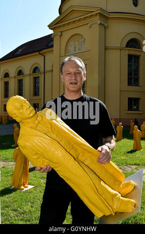 Neurippen, Deutschland. 6. Mai 2016. Der Künstler Ottmar Hoerl holding eine Figur des deutschen Schriftstellers Theodor Fontane vor der Kulturkirche in Neurippen, Deutschland, 6. Mai 2016. Die Figur ist Teil der Installation "Zwischen Den Welten" (lt. "Zwischen den Welten"). Mit einer Gesamtfläche von 400 Figuren des Künstlers will einen Impuls für die zeitgenössische Studie der Fontane-Jahre. Foto: Bernd Settnik/Dpa/Alamy Live News Stockfoto