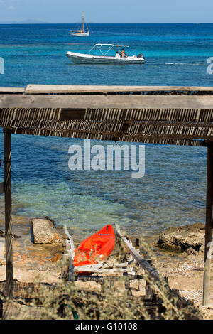 ELS Pujols Strand auf Formentera mit traditionellen Fischerboot und Kajaks im Sommertag. Llaüt Boote. Stockfoto