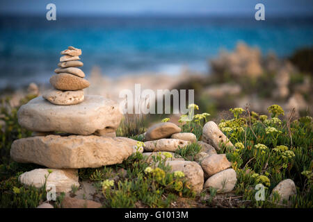 Zen-Raum. Steinen. Ses Illetes Strand, Balearen, Formentera, Spanien. Hintergrundbeleuchtung in den Sonnenuntergang mit Steinen mit verschiedenen Formen. "Die Flut" ("La Riada"), ein einzigartiger Raum mit Steinen von den deutschen Johannes Schultz gebaut. Stockfoto