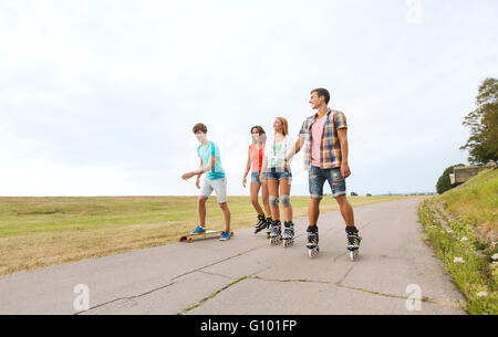 glückliche Jugendliche mit Skates und longboards Stockfoto