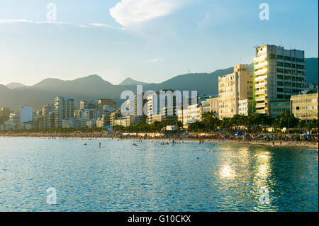Malerischen Sonnenuntergang Blick auf goldene Licht reflektiert auf ruhigem Wasser aus die Skyline der Stadt von Strand von Ipanema, Rio De Janeiro, Brasilien Stockfoto