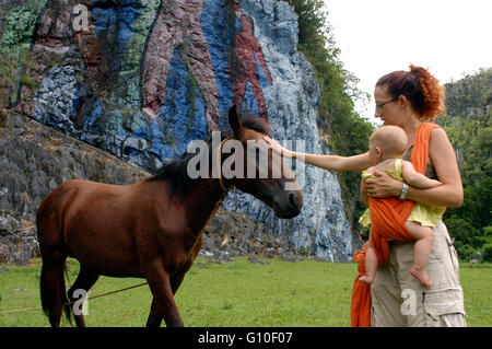 Mutter mit ihrem Baby und ein Pferd in der Vorgeschichte Wandbild, Pinar del Rio, Kuba. Gemalt in der Wand einer Klippe ist eines der beliebtesten Ausflugsziele in das Wahrzeichen Stockfoto