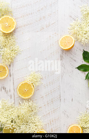 Holunderblüten und Zitronen auf eine Holzoberfläche. Zutaten für Holunderblüten-Sirup, rustikale Holz Hintergrund. Ansicht von oben, Leerzeichen Stockfoto