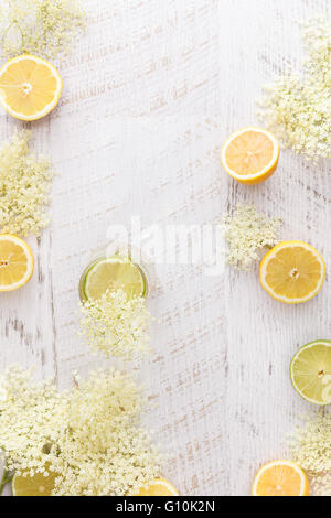 Holunderblüten cordial und Zutaten. Hausgemachter Holunderblüten Cordial mit Zitronen und Holunderblüten auf einem rustikalen Tisch. Stockfoto