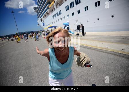 Reife Frau tanzt mit Musik am Eingang Kreuzfahrt im Hafen von Corfu, Griechenland Stockfoto