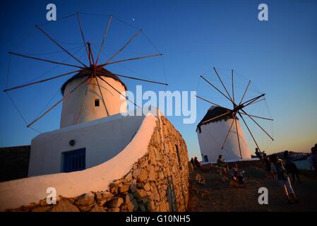 Die Menschen Sie genießen Sonnenuntergang aus traditionellen Windmühlen (Kato Milli) in die Stadt Mykonos, Griechenland Stockfoto