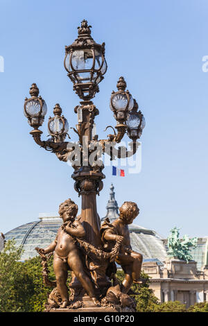 Laternenpfahl mit Bildhauerei an der Unterseite auf der Brücke Pont Alexandre III Stockfoto