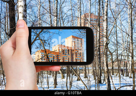 Saison Konzept - Tourist Fotos Appartementhaus durch Birken im Frühlingswald auf smartphone Stockfoto