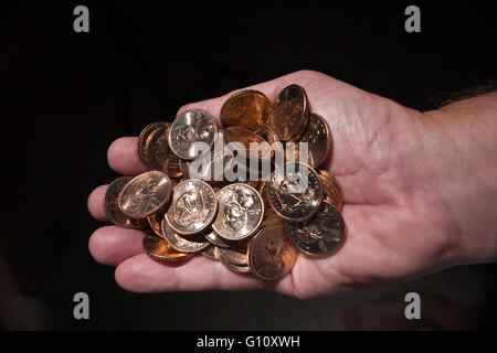 Älterer Mann Hand hält Dollar gold-Münzen mit native american Sacajawea Bild. Stockfoto