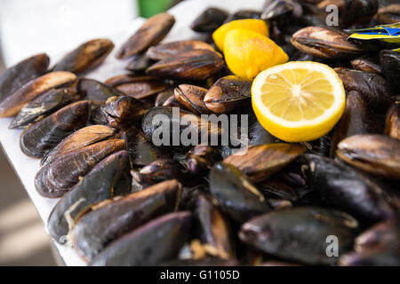 Türkischen Stil gefüllte Muscheln namens Midye Dolma auf der Bank zu verkaufen mit einem Stück Zitrone Stockfoto