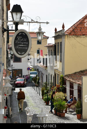 Engen und gepflasterten Straße mit Bars in der Stadt Funchal, Madeira, Portugal. Mit Menschen. Stockfoto