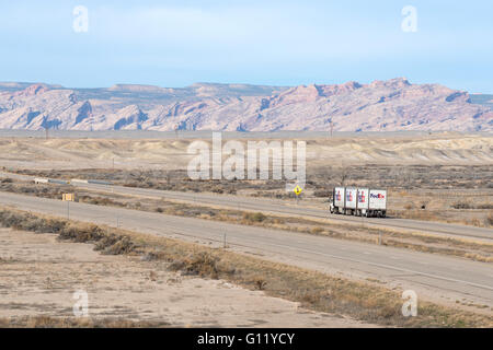 FedEx LKW auf der Interstate 70 im südlichen Utah.  Das San Rafael Swell ist im Hintergrund. Stockfoto