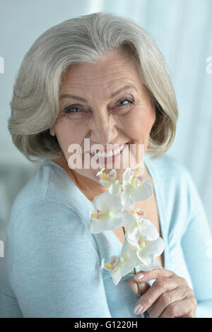 Ältere Frau mit blühenden Blumen Stockfoto