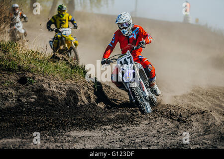 Gruppe-Racer auf einem Motorrad dreht auf einer staubigen Rennstrecke während Motocross Cup des Ural Stockfoto