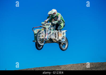 Motorradfahrer mit Beiwagen springen von einem Berg im Hintergrund des blauen Himmels während Cup des Ural Stockfoto