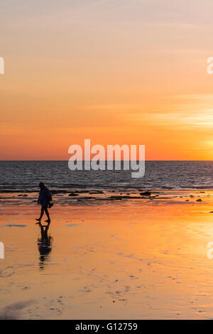 Einsamer Mann Spaziergänge Cable Beach bei Sonnenuntergang, Broome, Kimberley, Western Australia Stockfoto