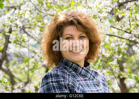 Porträt einer Frau mit lockigen Haaren im Frühlingspark Stockfoto