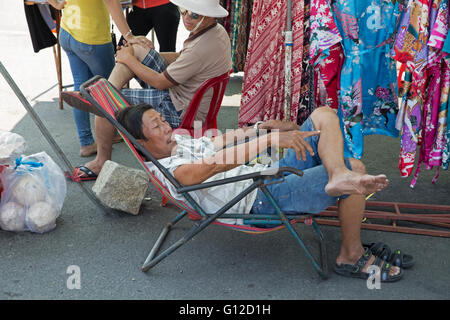 Ein Stall-Inhaber entspannt auf einem Markt in Nha Trang Vietnam Stockfoto