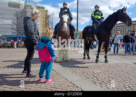 Junge Mutter und Tochter Blick auf Pferde und berittene Polizei Stockfoto