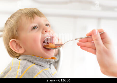 Baby Junge von seiner Mutter zu Hause gefüttert Stockfoto