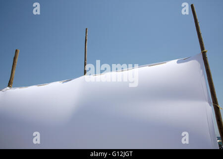 Nahaufnahme eines leeren weißen Leinwand gegen blauen Himmel Stockfoto