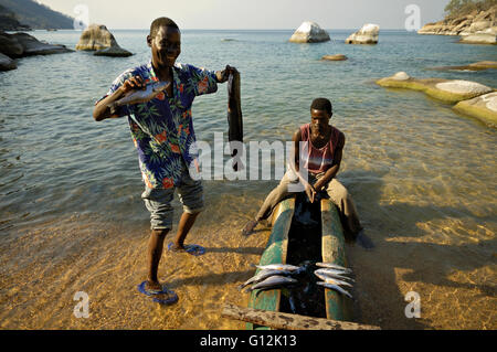 Fischer mit dem Einbaum-Kanu mit Fisch am Strand in Ilala Lücke, Lake Malawi National Park Stockfoto