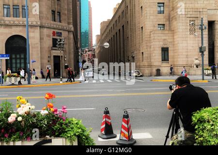 Ein Fotograf erfassen ein Hochzeitspaar auf der viel befahrenen Straße in der Nähe von Bund, Shanghai, China. Stockfoto